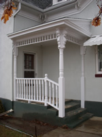Ornate front porch with fret work and railing